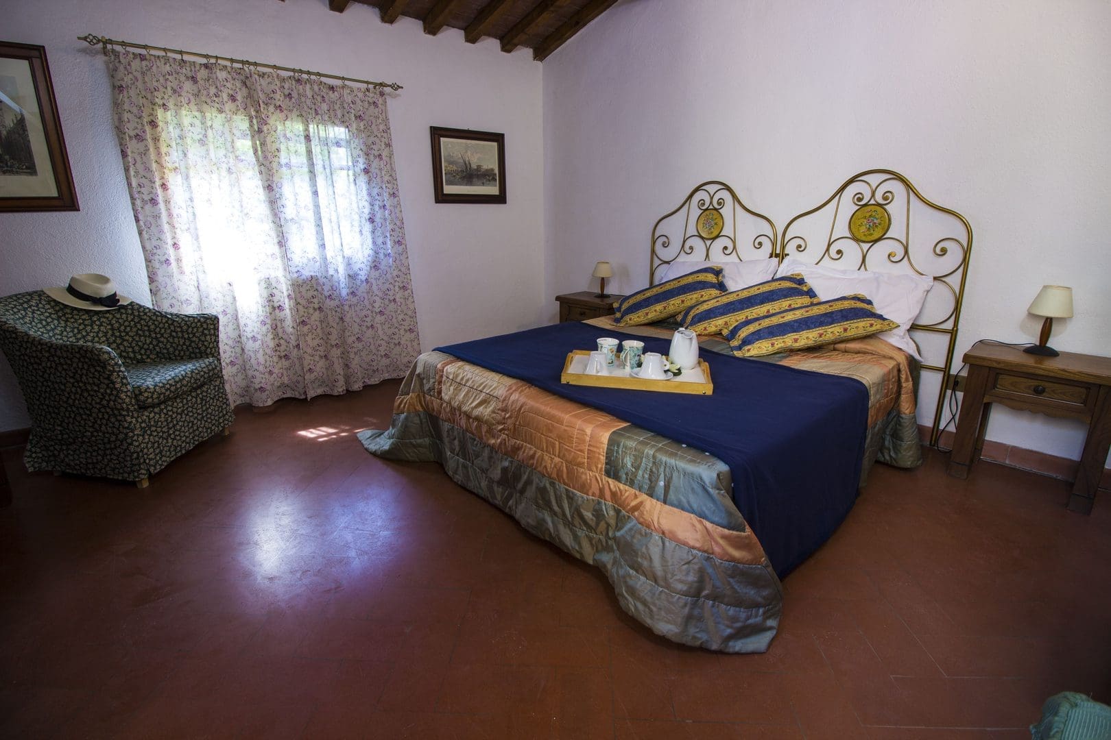 A bedroom with a bed, chair and window.