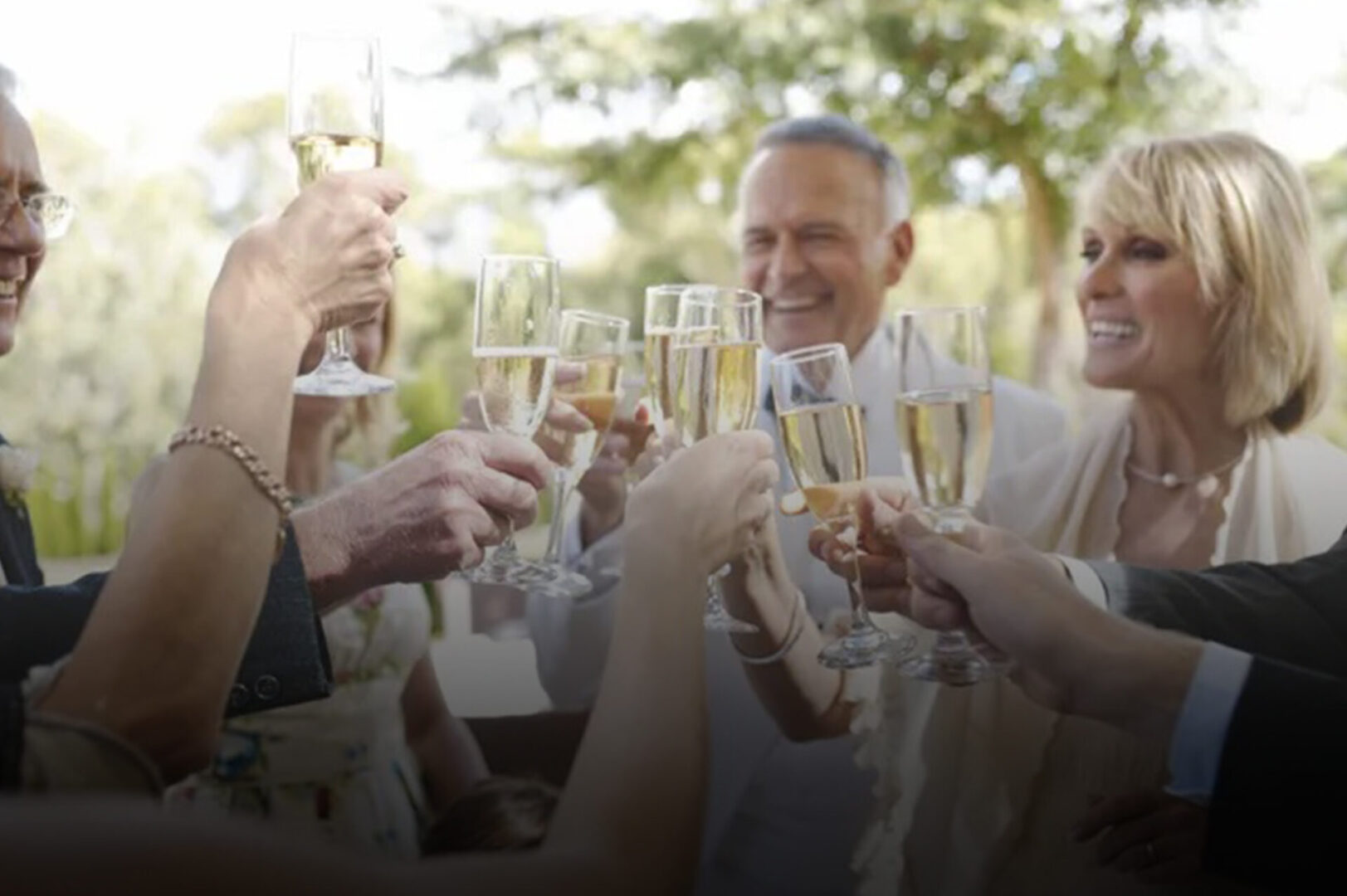 A group of people holding champagne glasses in their hands.