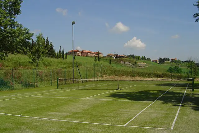 A tennis court with two rackets and one ball