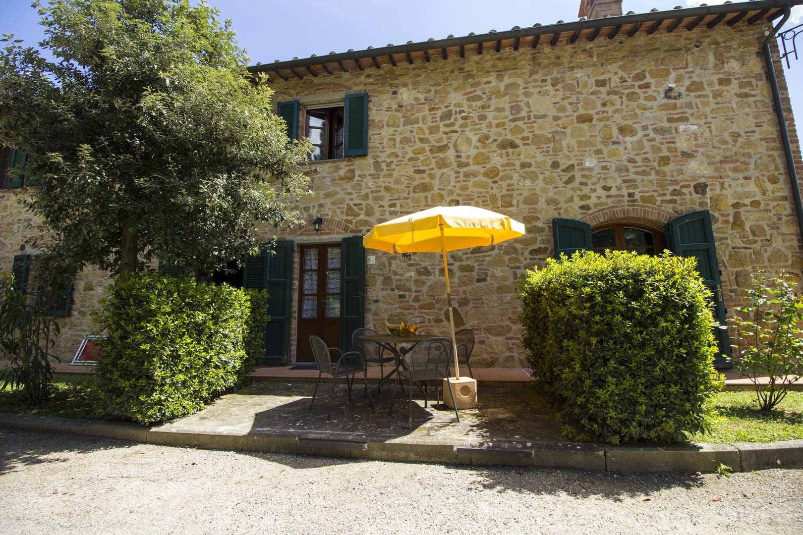 A yellow umbrella is in front of the house.