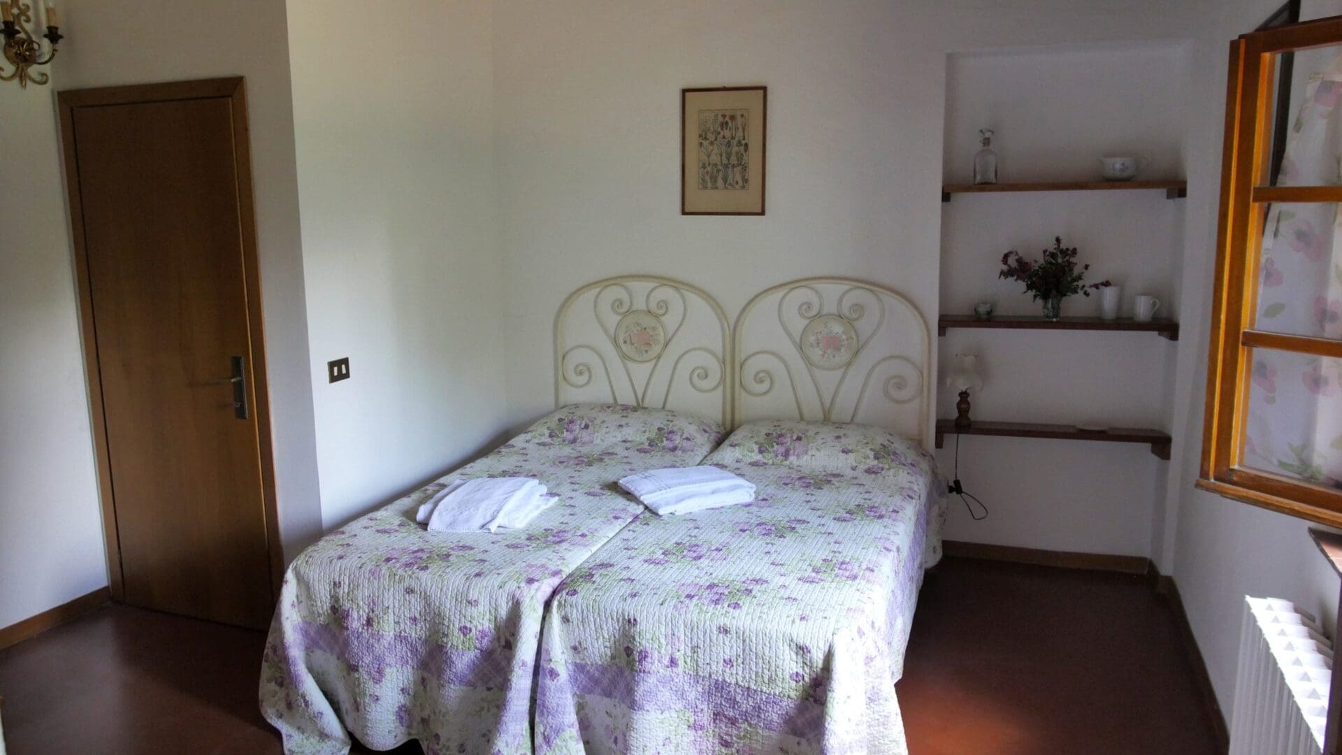 A bedroom with two beds and a book shelf