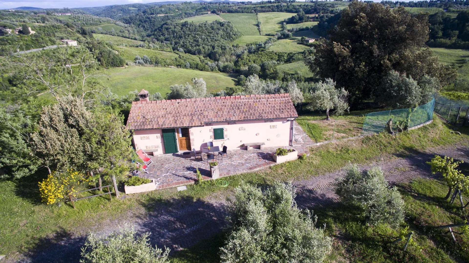 An aerial view of a house with trees in the background.