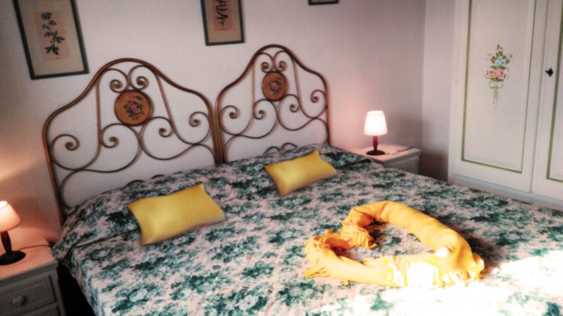 A bed with yellow pillows and green sheets.