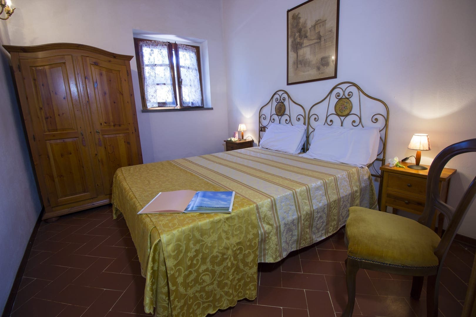 A bedroom with a bed, two nightstands and a window.