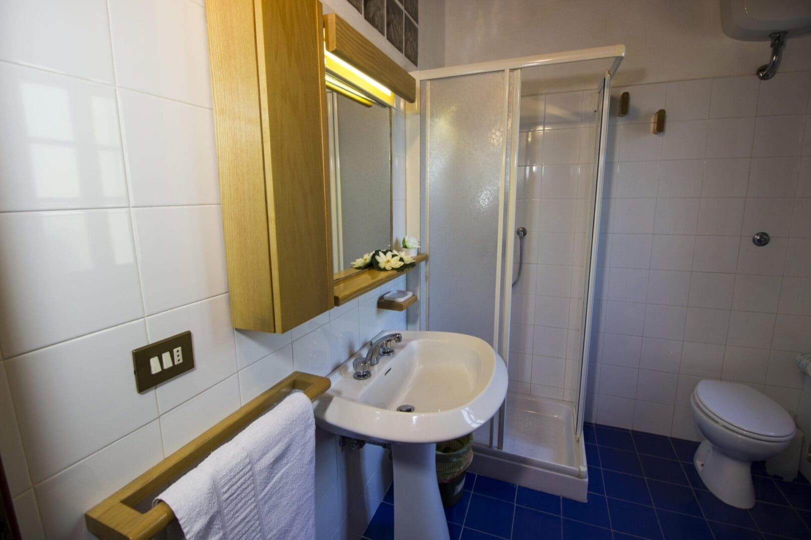 A bathroom with a sink, mirror and shower.