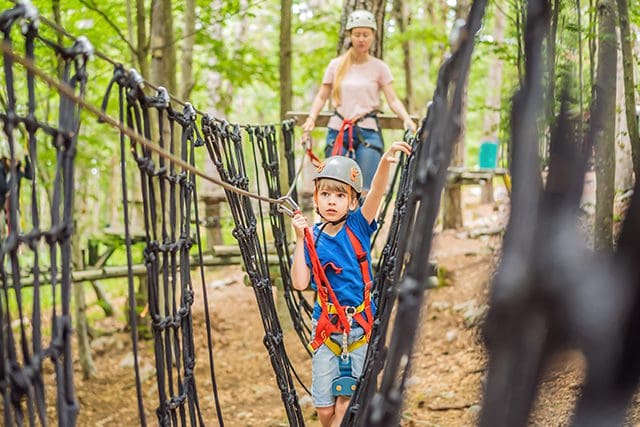 A young boy and woman on ropes course.