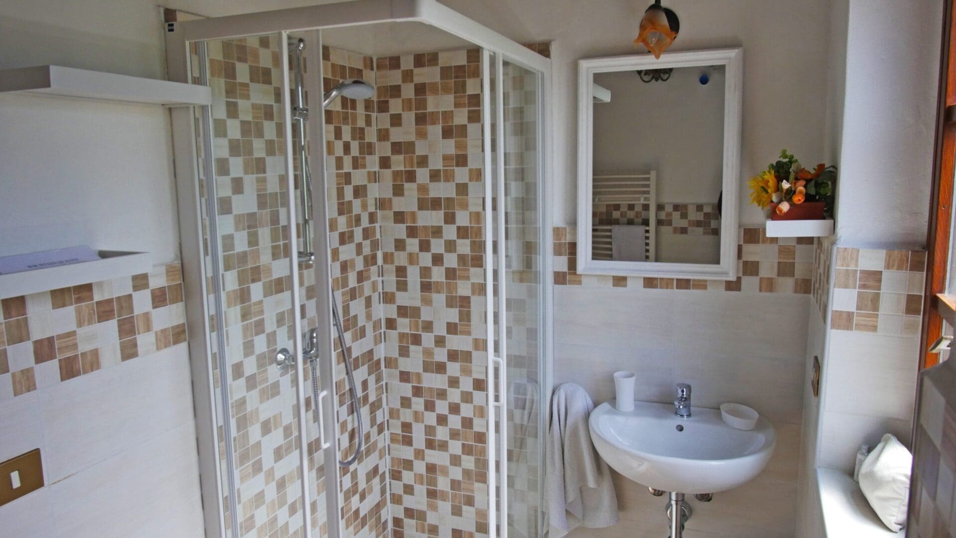 A bathroom with a sink, mirror and shower.