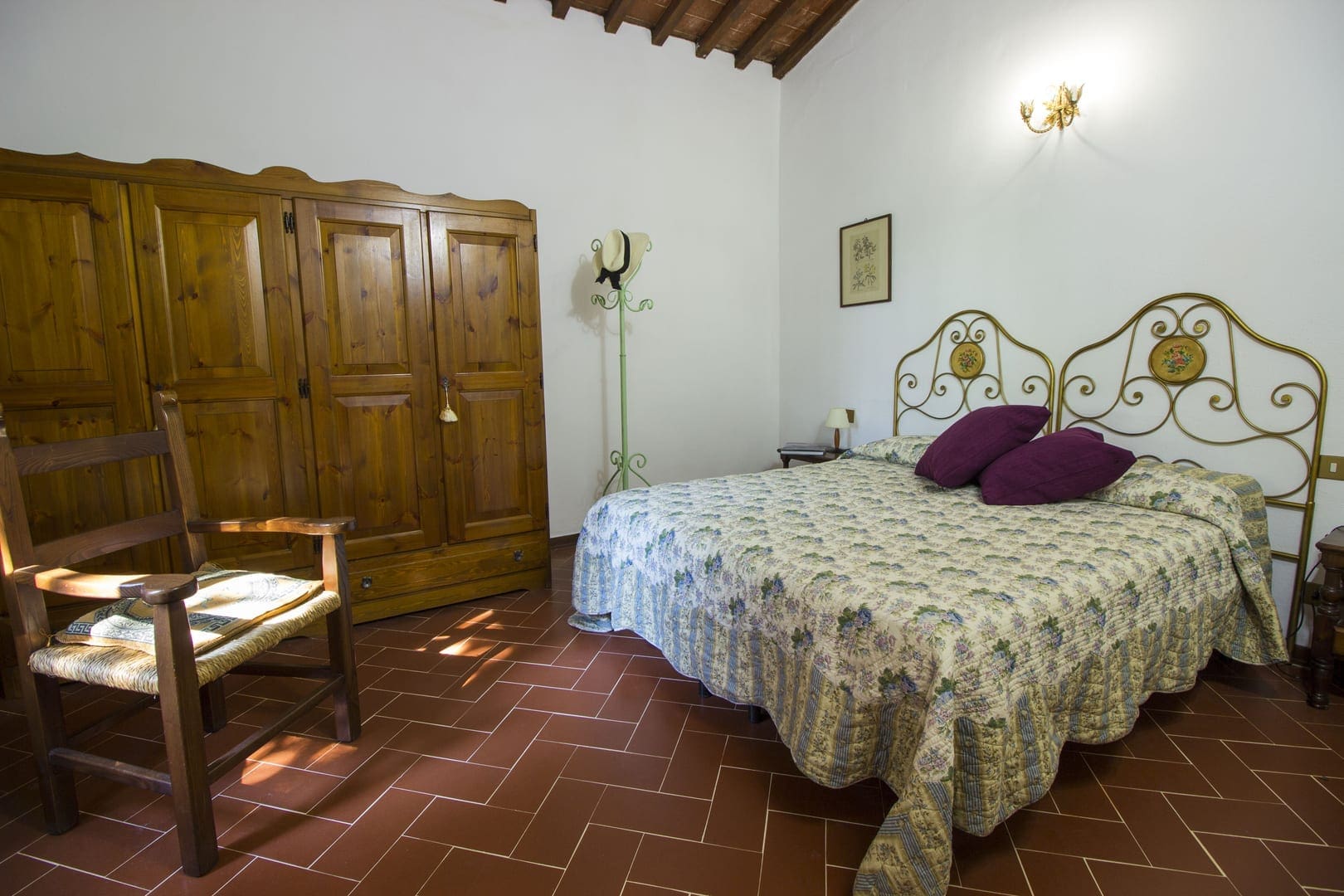 A bedroom with a bed, chair and two wardrobes.