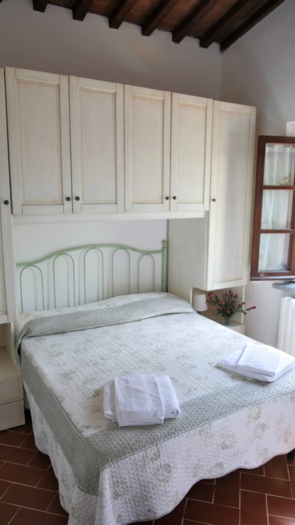 A bed room with a white bed and some cabinets