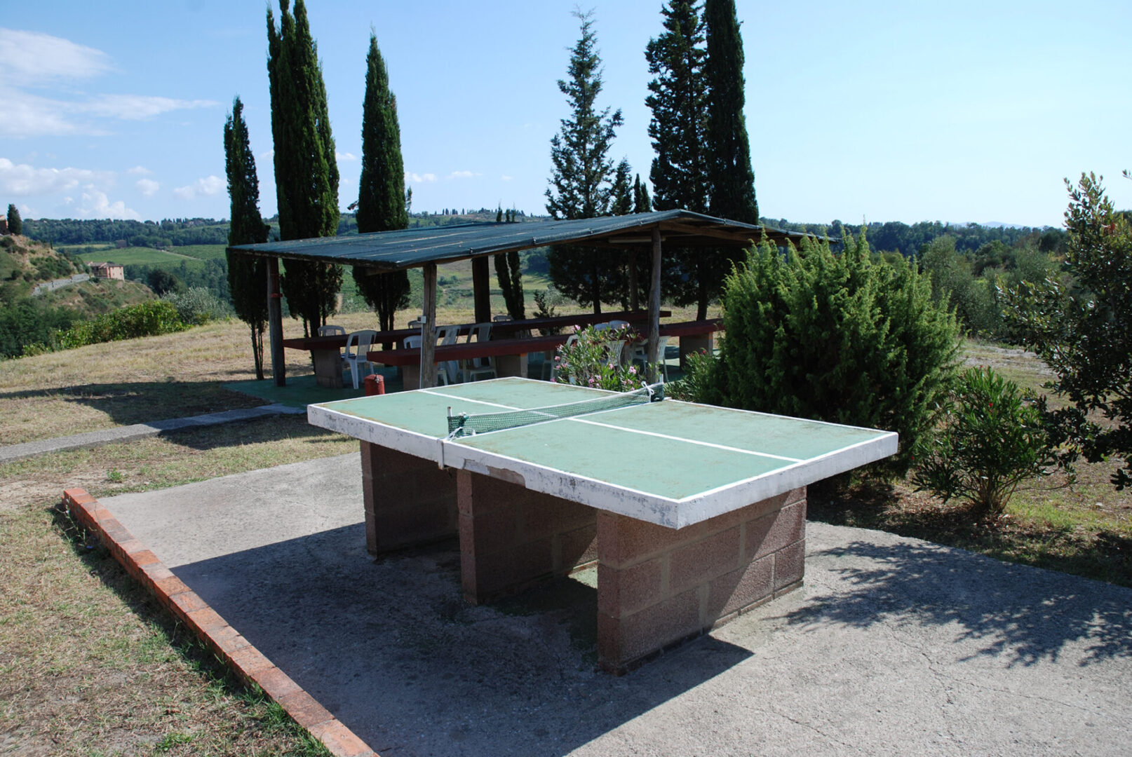 A table tennis table in the middle of an outdoor court.
