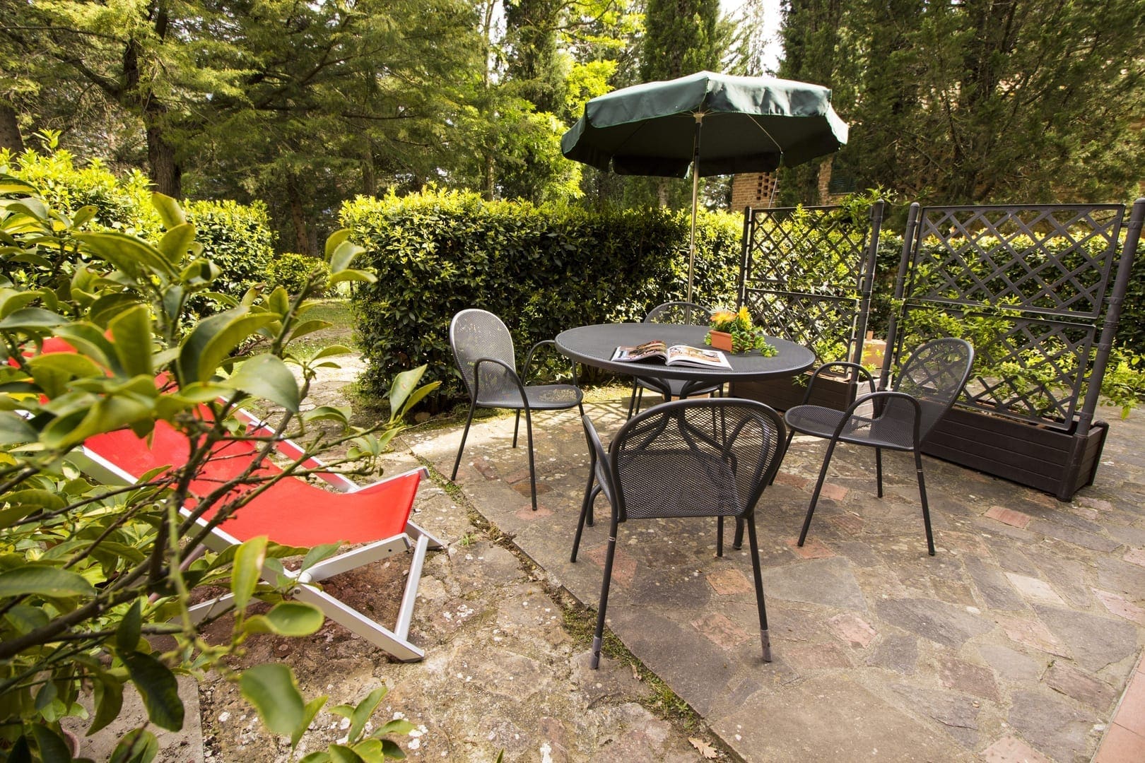 A patio set with an umbrella and chairs.