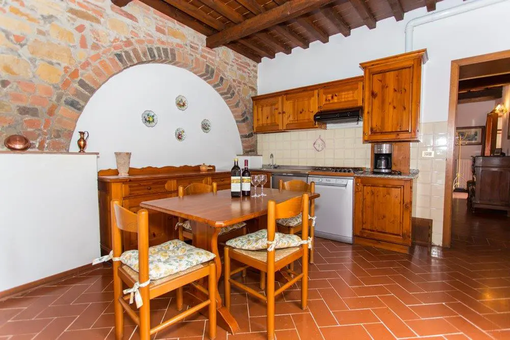A kitchen with wooden furniture and tile floors.