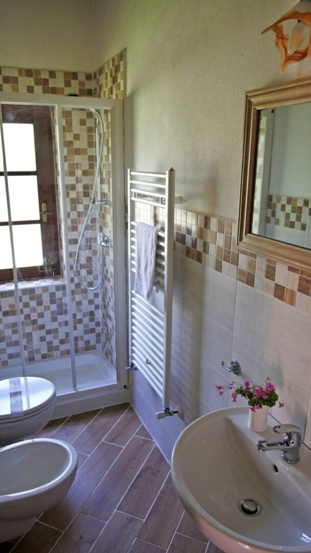 A bathroom with a toilet, sink and shower.