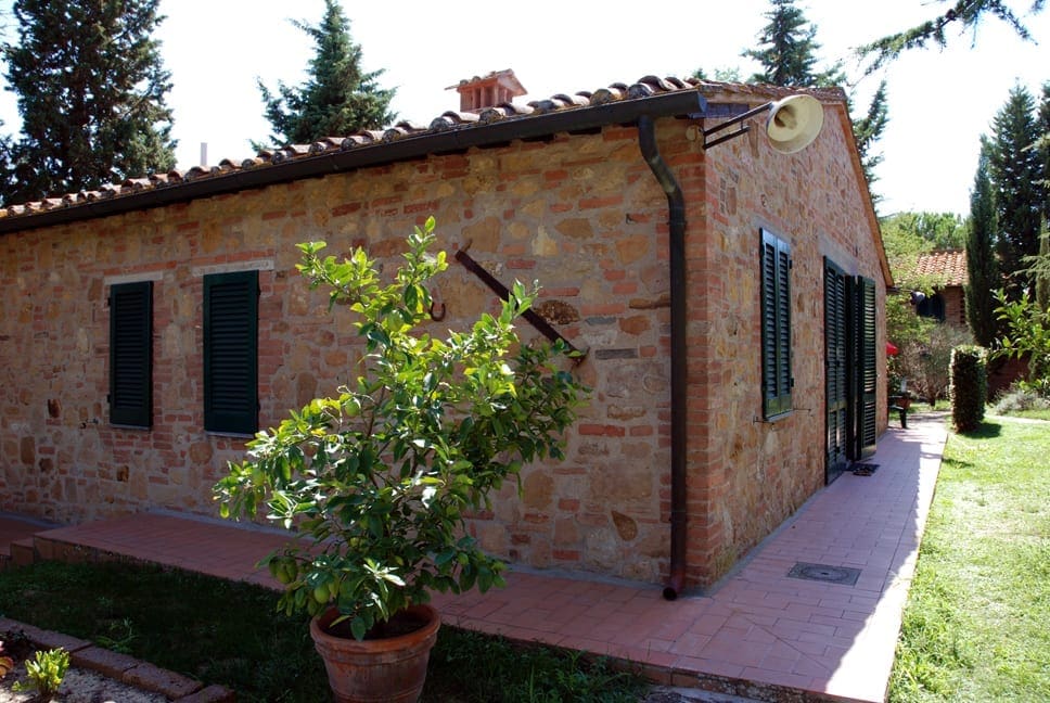 A brick house with a potted plant in front of it.