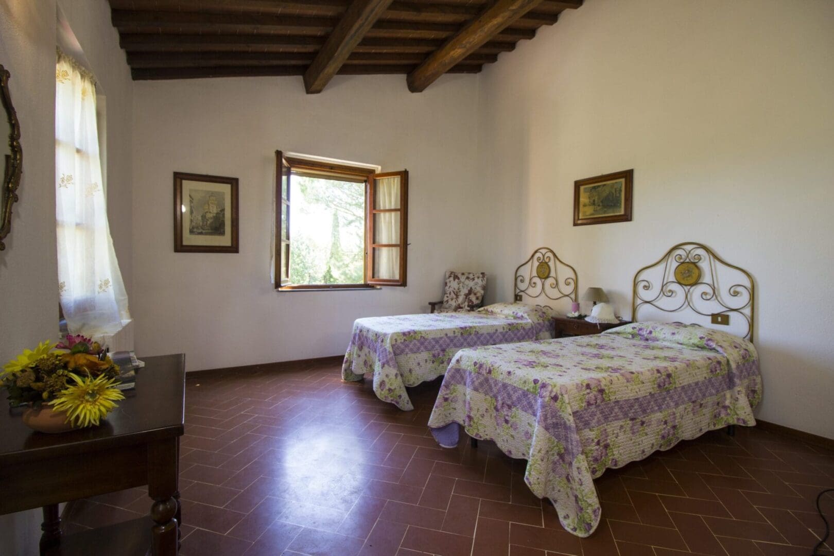 A bedroom with two beds and a window.