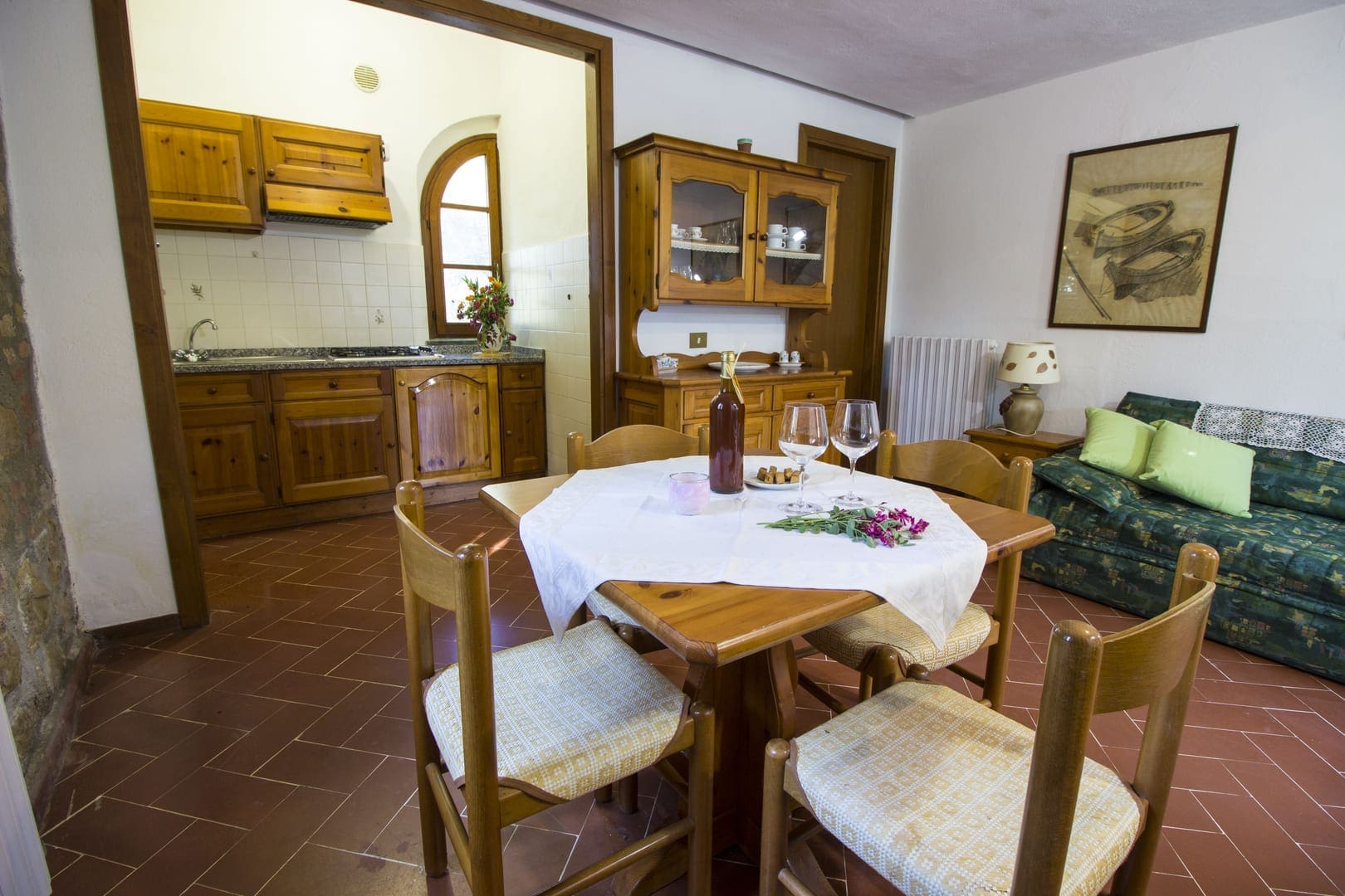 A dining room table with chairs and wine glasses on it.