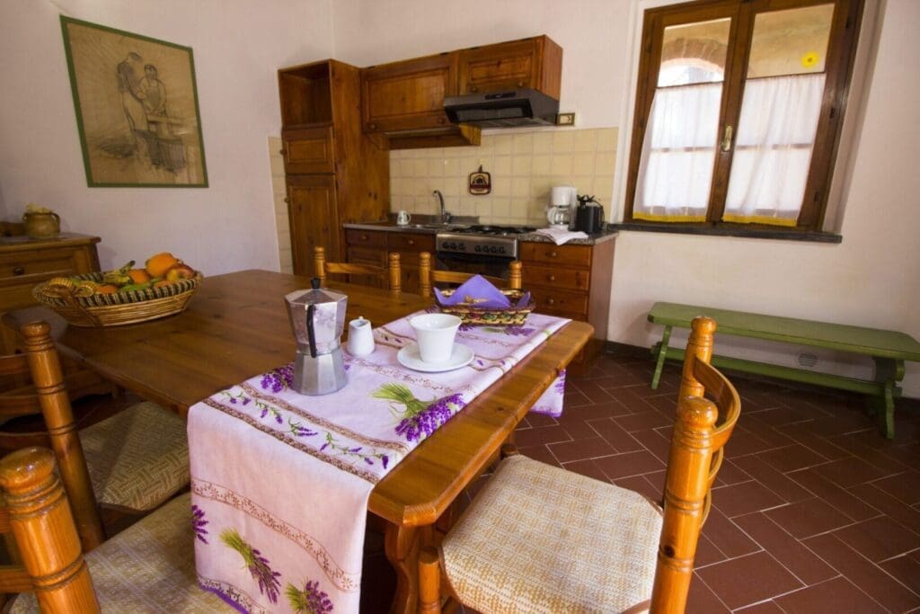 A kitchen with a table and chairs, a stove and a microwave.